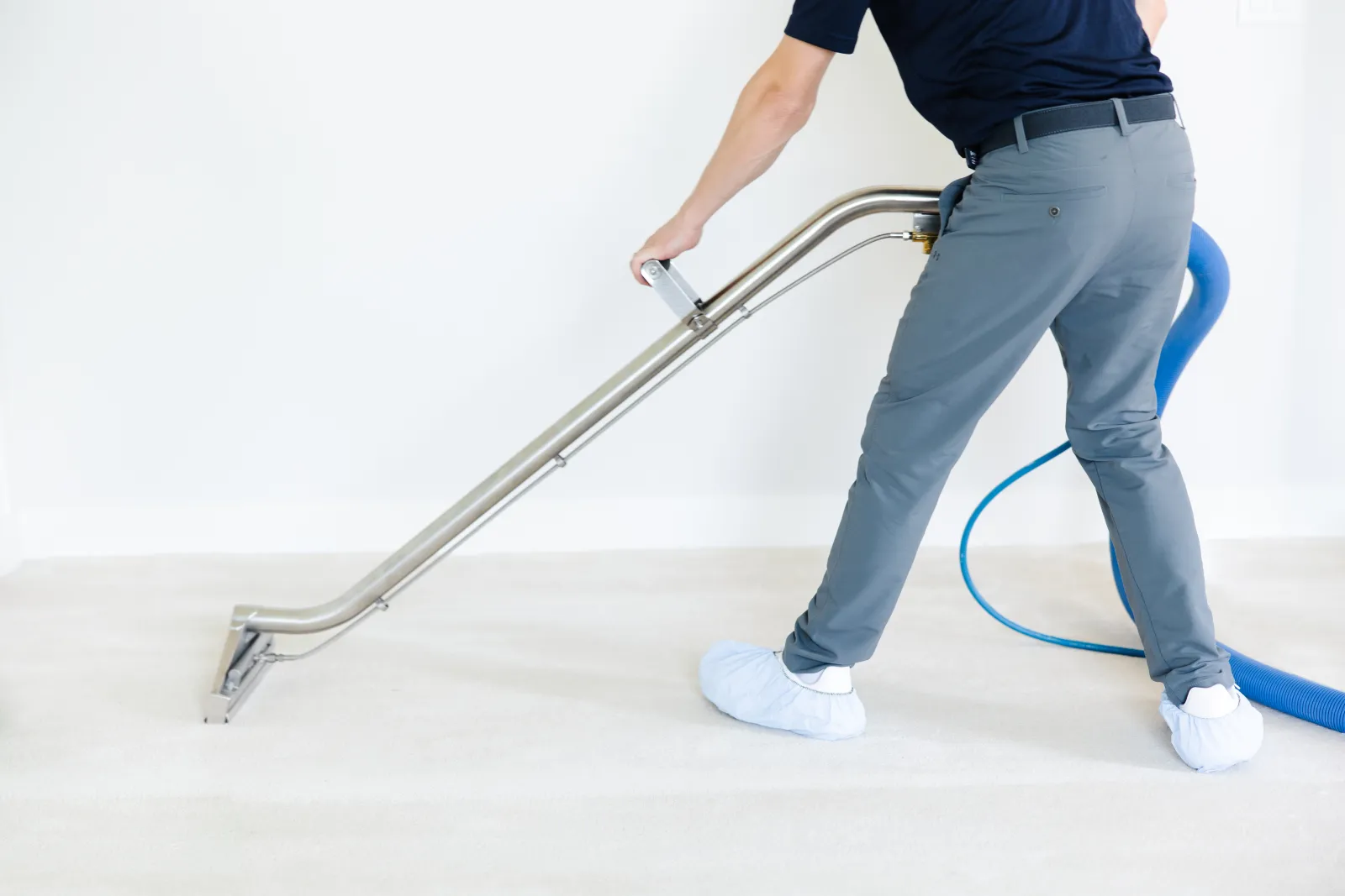 Zerorez&reg; technician cleaning a white carpet in an empty room for a move out carpet cleaning