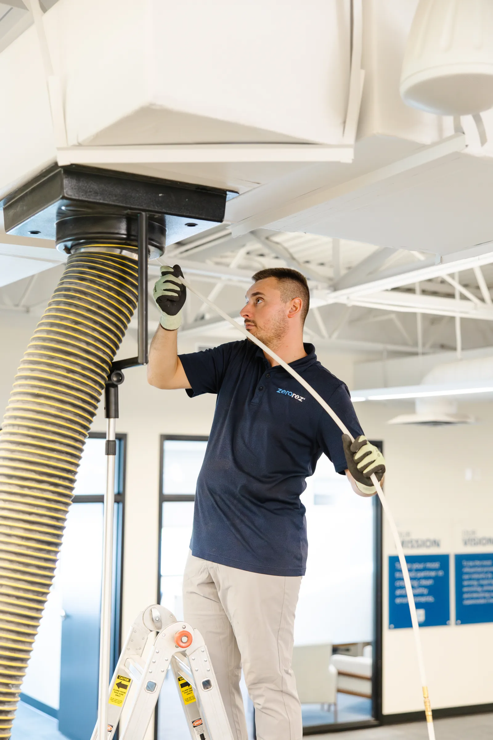 zerorez technician cleaning air duct in office