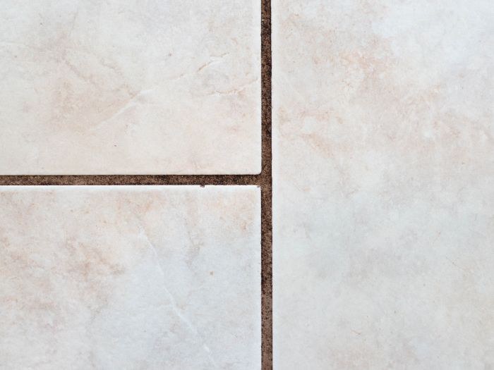 a close-up of white tile with dirty grout lines